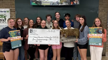 Community Foundation of Northeast Michigan Youth Advisory Council Members pose with a $505.00 check and posters advertising YAC Day